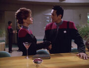 Chakotay and Archer shake hands at the bar of the a recreation of the Quantum Café, Archer's Klingon Martini rests on the bar top