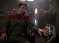Tim Watters uses the intercom on the USS Valiant in 2374