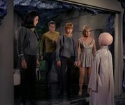 Several Starfleet crew standing before a Talosian