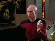 Picard entnimmt Q den Phaser