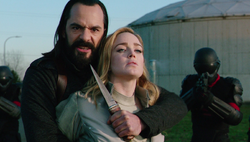 Vandal Savage holding a knife on Sara