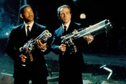 Agent K with the Pulsar Blaster, and Agent J with the Arquillian Arm Cannon (Tri-Barrel Pulsar Blaster).