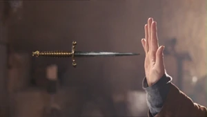 Merlin deflects a dagger with magic.