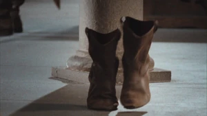 Merlin enchants Mordred's boots.