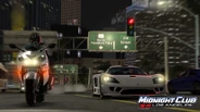 A Saleen S7 races against a sports bike on the freeway in in-game Downtown Los Angeles.