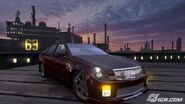 A Cadillac CTS-V parked at a dock in San Diego. A large ship and some industrial areas can be seen behind it.