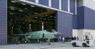 A unpainted F-35 taxing off the assembly line