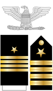 The eagle, shoulder boards, and dress blue sleeve stripes of a U.S. Navy captain (Line officer)