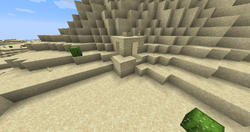 A well partially buried in sand.
