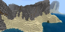 Une côte rocheuse ensablée avec des collines.