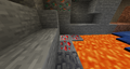 A vein of redstone ore next to some lava.