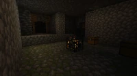 A dungeon with a Monster Spawner in the center, and two chests. The torch was placed by the player.
