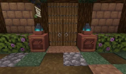 Two decorated pots holding soul lanterns at the entrance to a building.