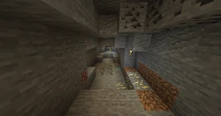 Múltiples vetas minerales en una cueva. Mena de diamante y mena de redstone, así como mena de carbón y mena de oro son visibles en la distancia.