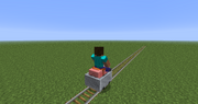 Player on saddled pig in a minecart