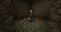 Een kerker met een Monsterspawner in het midden en twee kisten. De fakkel is geplaatst door de speler.