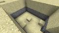 A dungeon at sea level covered by sand.