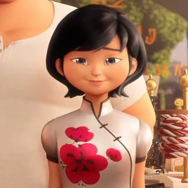 Sabine siedząca przy stole z głową trochę obróconą w jej prawo