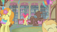 Apple Bloom stands next to the chocolate pony S1E12