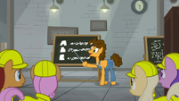 Cheese in front of a chalkboard S9E14