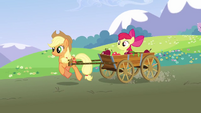 Apple Bloom, in a wagon being pulled by Applejack.