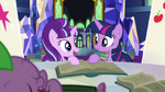 Starlight and Twilight look at each other while holding book S5E26