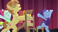 Feather Bangs appears on stage with a chair S7E8