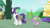 Rarity levitating the book towards Spike's hands S4E23