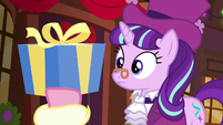 Spirit of HW Presents holding up medium-sized present S6E8