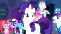 Rarity looks at her friends while blushing S6E9