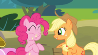 Pinkie Pie eating an apple while Applejack is singing S4E09