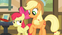 Apple Bloom pushes Applejack away from the quill S4E09