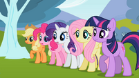 The ponies look on.