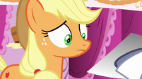 Applejack looks skeptical at the photograph S7E9