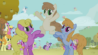 Three ponies cheer on.