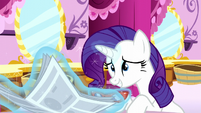 Rarity puts her newspaper and glasses down S6E9