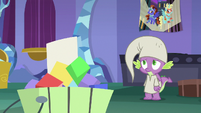 Spike looks at brochure in the trash S9E19