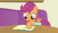 Scootaloo pasting a photo in her scrapbook S7E7