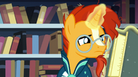 Sunburst closely reading a spell book S7E1