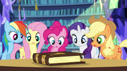Twilight's friends looking at the storybook EG2