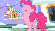 Pinkie Pie mit einem Lebkuchenhaus.