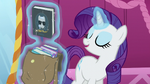 Rarity levitates one of the books from the bag S5E22