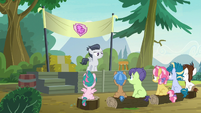 Rumble singing to campers from a stage S7E21