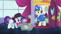 Rarity levitates crumpled papers out from the package S5E15