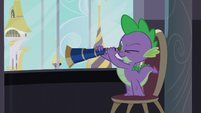 Spike looking out the window with a telescope S5E10