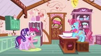 Mrs. Cake frosting a cake S6E6