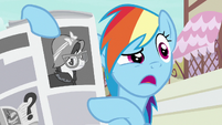 Rainbow Dash holding a newspaper article of A. K. Yearling S7E18