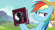 Rainbow Dash holding Shadow Spade book S8E17