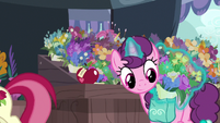 Sugar Belle puts flowers in her saddlebag S9E23