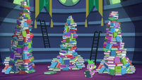 Spike standing besides the mountains of books S5E22